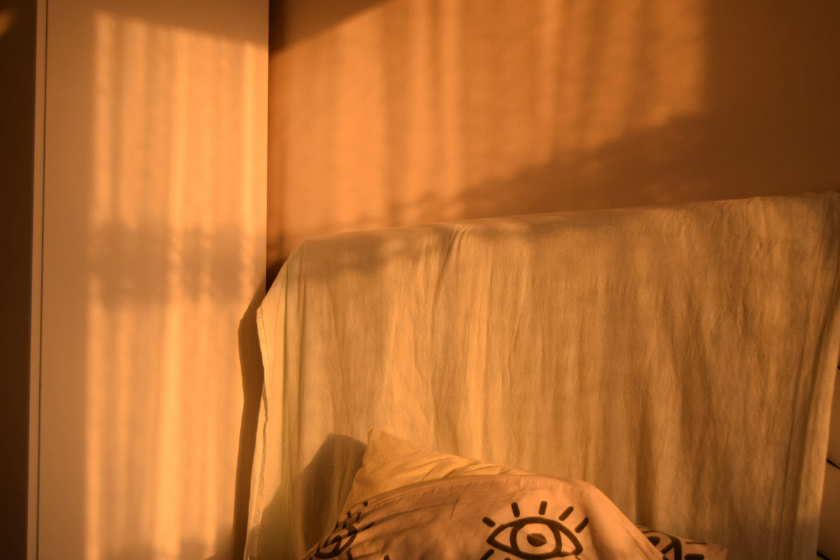 Lumière dorée et chaude projetée sur le mur d’une chambre, comme en fin de journée