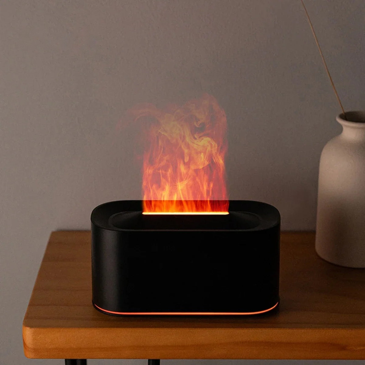 Diffuseur effet flamme noir allumé sur une table de chevet